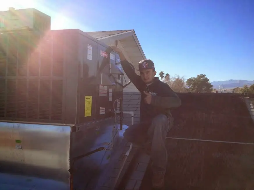HVAC technician performing HVAC Inspection on a rooftop unit in Hudson